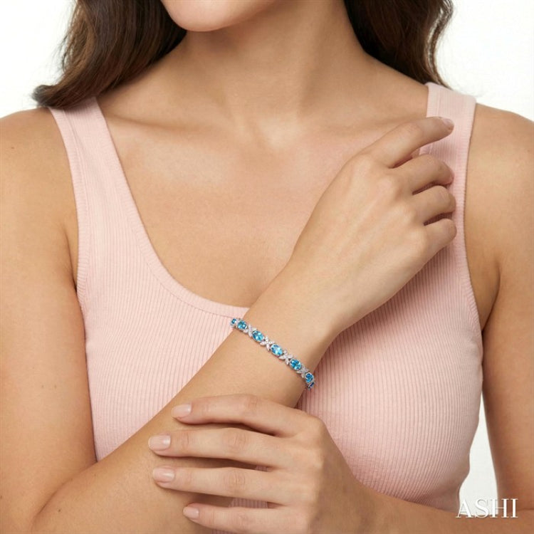 7X5 MM Oval Cut Blue Topaz and 1/10 Ctw Round Cut Diamond Semi-Precious Bracelet in Sterling Silver
